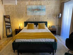 瓦莱塔Babel Suites的一间卧室配有一张带黄色枕头的大床