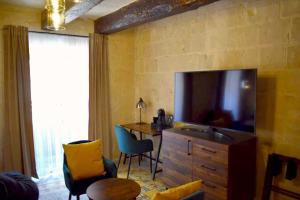 瓦莱塔Babel Suites的客厅配有电视和桌椅