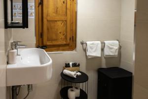 瓦莱塔Babel Suites的白色的浴室设有水槽和木柜