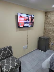 开普敦MIRAJO Guest House的墙上配有平面电视的房间
