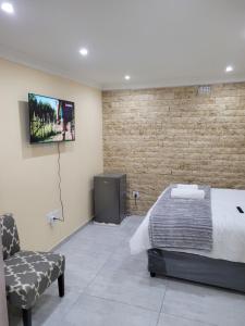 开普敦MIRAJO Guest House的一间卧室配有一张床,墙上配有电视