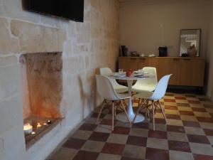 马泰拉Dimore dei Mercanti的一间带桌椅和壁炉的用餐室