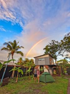 安加罗阿Moehiva Camping Rapa Nui的站在一座有彩虹的房子前面的女人