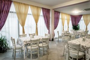 希萨里亚Astrea Deluxe的用餐室设有桌椅和窗户。