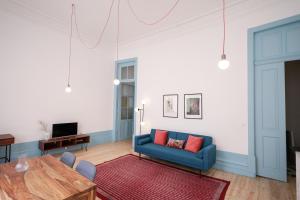 波尔图Adorable Apartments in Great Area的客厅配有蓝色的沙发和桌子