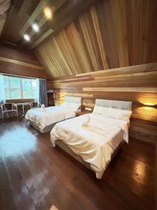 仙本那仙本那中梁度假庄园 ZhongLiang Holiday Garden Semporna的木墙客房的两张床