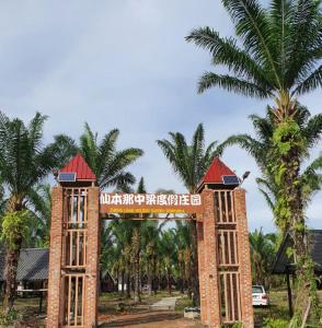 仙本那仙本那中梁度假庄园 ZhongLiang Holiday Garden Semporna的棕榈树度假村入口处的大门