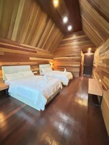 仙本那仙本那中梁度假庄园 ZhongLiang Holiday Garden Semporna的木墙客房的两张床