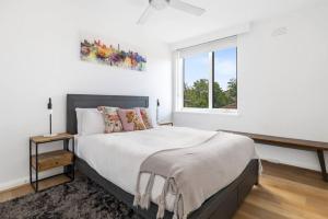 墨尔本South Yarra apartment with stunning views的白色的卧室设有一张大床和一个窗户