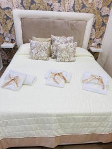 那不勒斯La Dimora Dei Sogni的白色的床上有白色的毛巾和弓