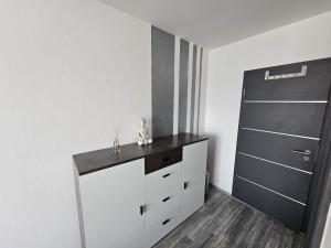 芬肯施泰因Orchidea3的卧室配有白色梳妆台和黑色门