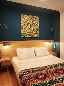 昆卡Hotel Casa Merced的卧室配有一张床,墙上挂有绘画作品