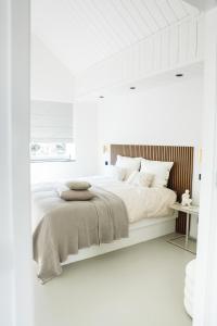 BeersStijlvol huisje in de Brabantse natuur! Tuynloodz B的白色卧室设有一张白色墙壁的大床