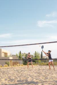 珀彻斯White Shell Beach Villas的两名妇女在海滩上打网球