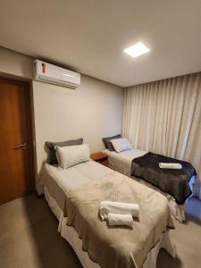 因巴塞Apartamento Super Charmoso Condomínio OAHU Alto do Imbassaí的一间医院房间,配有两张带毛巾的床