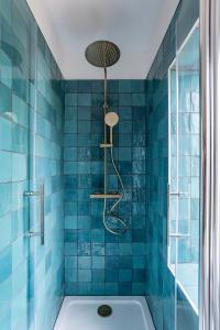 斯特拉斯堡Petit Manoir en Ville - Golden Tree - Parking privé的蓝色瓷砖浴室设有浴缸和淋浴。