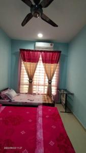 PendangHomestay An-Nur Residensi Pendang的一间卧室配有吊扇和一张带红色毯子的床。