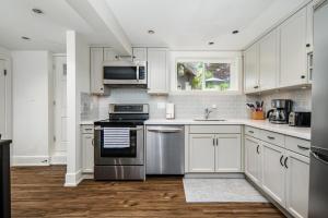 温哥华Gorgeous 4-Bedroom Garden Level Suite at Vancouver West的厨房配有白色橱柜和不锈钢用具