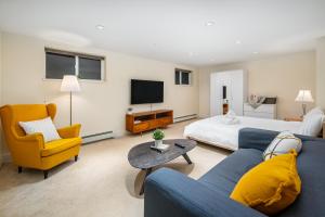 温哥华Gorgeous 4-Bedroom Garden Level Suite at Vancouver West的客厅配有蓝色的沙发和床。
