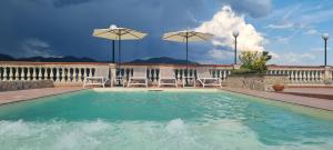 卡瓦德蒂雷尼Villa Marina的一个带两把椅子和遮阳伞的游泳池