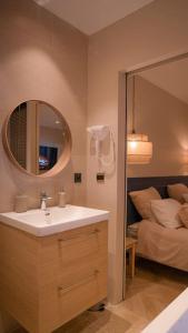 科洛布里埃Suite de Luxe Jacuzzi balnéo,King size Bed的一间带水槽和镜子的浴室以及一张床