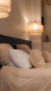 科洛布里埃Suite de Luxe Jacuzzi balnéo,King size Bed的一间卧室配有带白色枕头的床