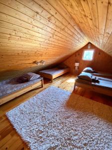 HiiumaaMänniliiva puhkemaja的一间木制客房,配有两张床和地毯