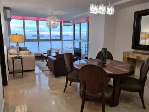 巴拿马城Amplio y hermoso apartamento frente a la bahía.的一间带桌椅的用餐室和一间客厅