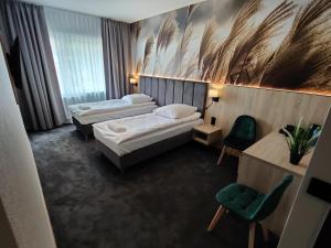 日拉尔杜夫Nowe M4 Żyrardów Centrum - blisko Suntago的酒店客房,设有两张床和一把绿色椅子