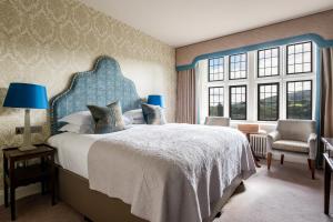 莫顿汉普斯泰德博维城堡酒店的一间卧室配有一张大床和蓝色床头板