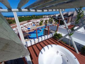 皮帕Pipa Brisas do Amor的设有一个游泳池的度假村阳台,享有风景