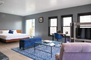 丹佛Good Hotels Downtown Denver的客厅配有床、沙发和桌子