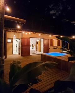 托兰克索Vila dos Macacos Trancoso的后院,设有游泳池和厨房,晚上