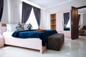 KwedonuExotic Palace Hotel的一间卧室配有一张带蓝色毯子的大床