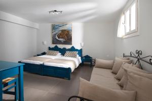 迈伊斯蒂Poseidon Hotel的一间卧室配有一张床和一张沙发