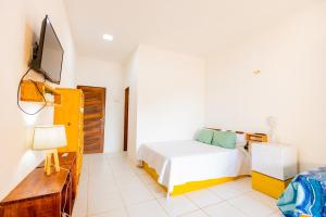 巴纳伊巴OYO Hotel Das Pedras的一间卧室配有一张床,墙上配有电视