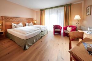 阿滕多恩Struck Landhotel & SPA的酒店客房设有一张大床和一张书桌。