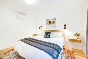 门多西诺Peaceful Mendocino Cottage Surrounded By Redwoods的卧室配有一张带条纹毯子的大型白色床