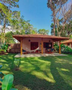 托兰克索Vila dos Macacos Trancoso的庭院内带吊床的房子