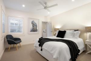 悉尼Beach Retreat的白色卧室配有床和椅子
