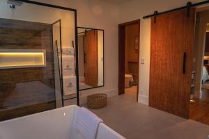 伊泰帕瓦Saison Resort & Spa的带浴缸和玻璃淋浴间的浴室。