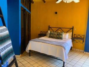 巴亚尔塔港VILLA OASIS的卧室配有蓝色和黄色墙壁上的床铺