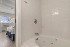 旧奥查德比奇Mt Royal Motel的带浴缸的浴室和卧室