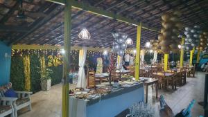 阿拉夏奇巴海滩Pousada Tropical Araçatiba的一间设有一张餐桌的餐厅,配有食物和气球