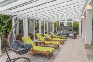 阿滕多恩Struck Landhotel & SPA的庭院中设有带椅子和吊床的温室