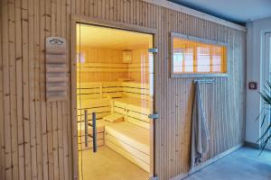阿滕多恩Struck Landhotel & SPA的一间设有木墙和玻璃门的桑拿浴室