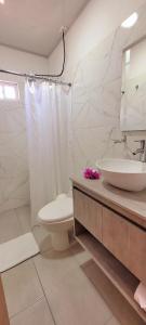 普罗维登西亚Colorful Garden House的白色的浴室设有水槽和卫生间。