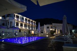 阿齐欧斯·贡多斯Kostas Beach Apartments的夜间设有游泳池的酒店