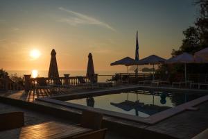 阿齐欧斯·贡多斯Kostas Beach Apartments的度假村的游泳池配有椅子和遮阳伞