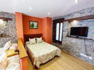 莫利纳塞卡Hotel Rural Pajarapinta的一间卧室设有一张床和石墙